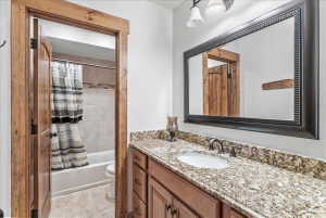 Bathroom vanity featuring a granite countertop, undermount sink, and dark bronze hardware