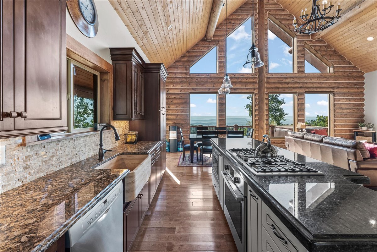 Kitchen featuring wood-finish flooring, granite countertops, and dark wood cabinetry