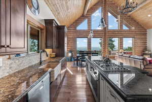 Kitchen featuring wood-finish flooring, granite countertops, and dark wood cabinetry