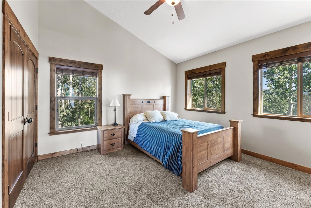 Spacious room featuring vaulted ceilings, light-toned walls, and plush carpeting