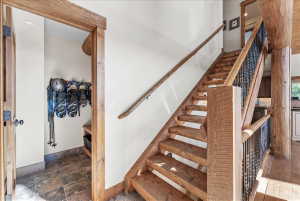 Wood-finish staircase with wrought iron balusters and a prominent wood newel post