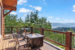 Expansive wood deck with a built-in fire pit and wood railings