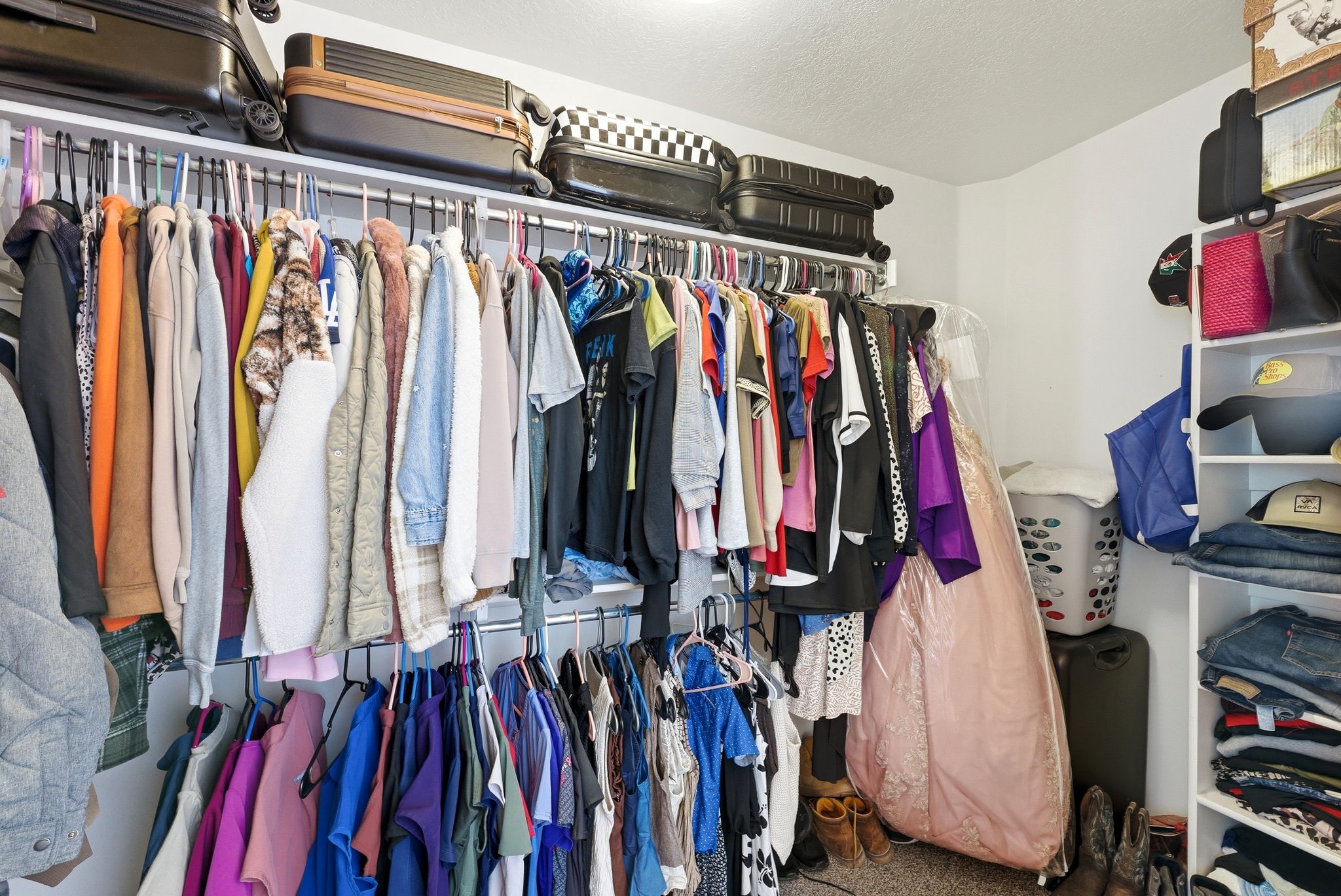 Integrated closet system featuring multiple hanging rods, overhead shelving, and a built-in shelving unit with open compartments