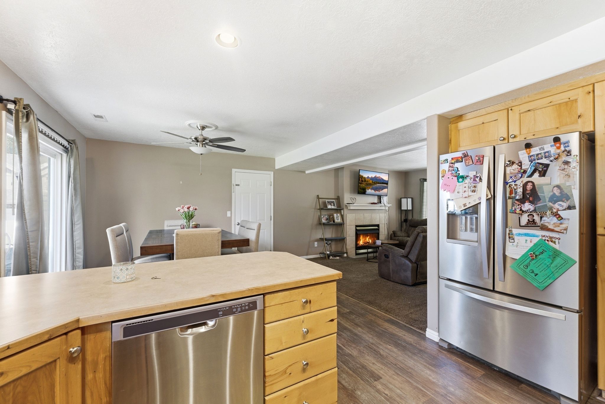 Kitchen featuring wood cabinetry, stainless steel dishwasher, and stainless steel refrigerator