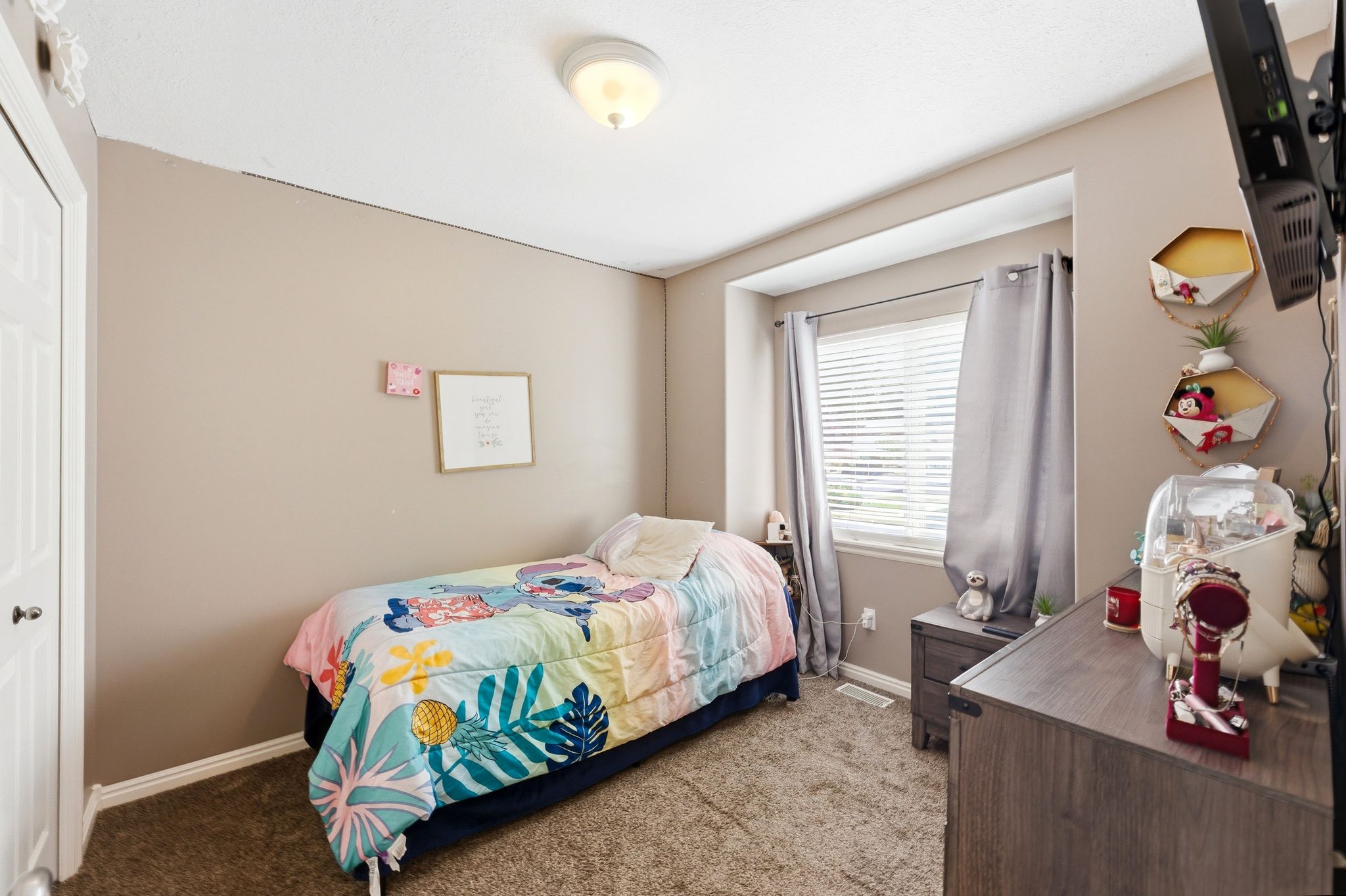 Carpeted room featuring a white paneled door, a single window with blinds, and a neutral wall color