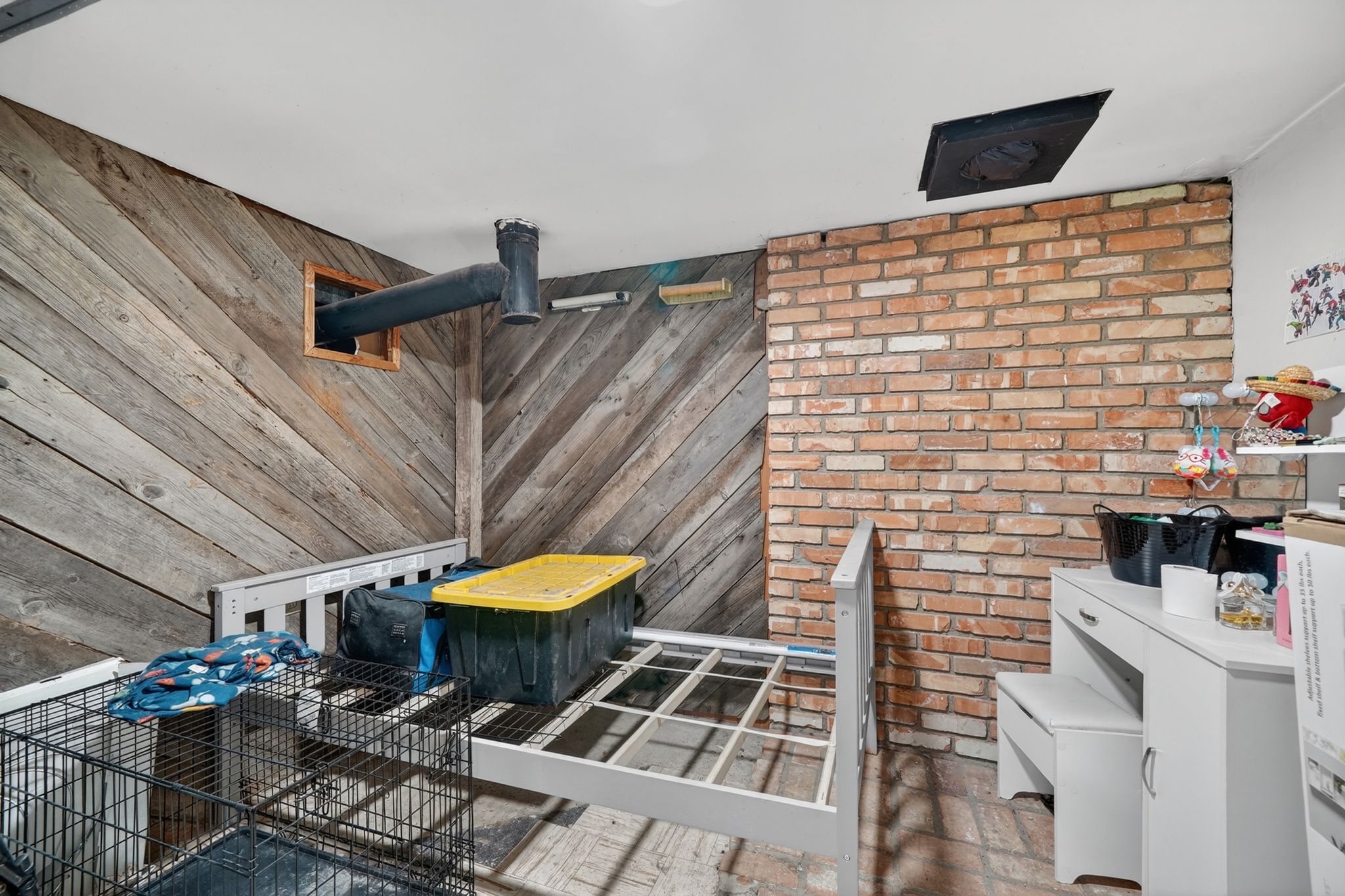 Exposed brick accent wall with a diagonal wood-panel feature wall