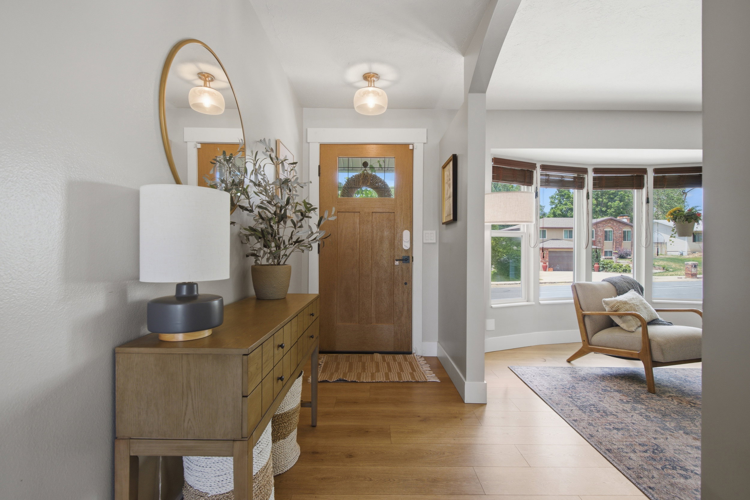 Inviting entryway featuring a natural wood-finish door with decorative glass, wood-finish flooring, and a contemporary flush-mount ceiling light