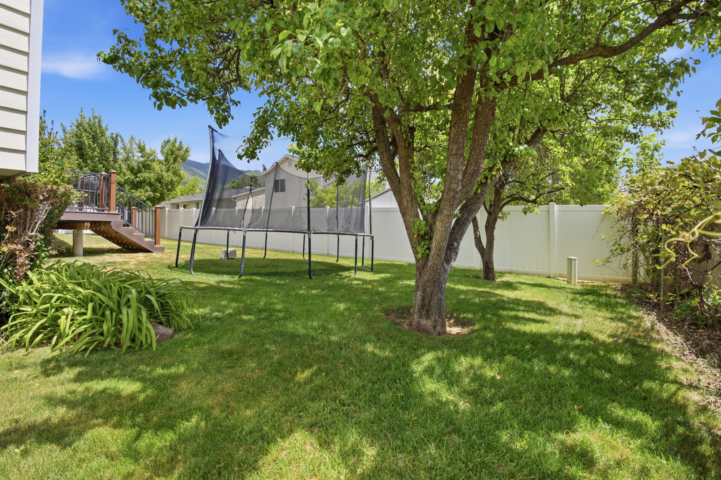 Expansive green lawn featuring mature shade trees