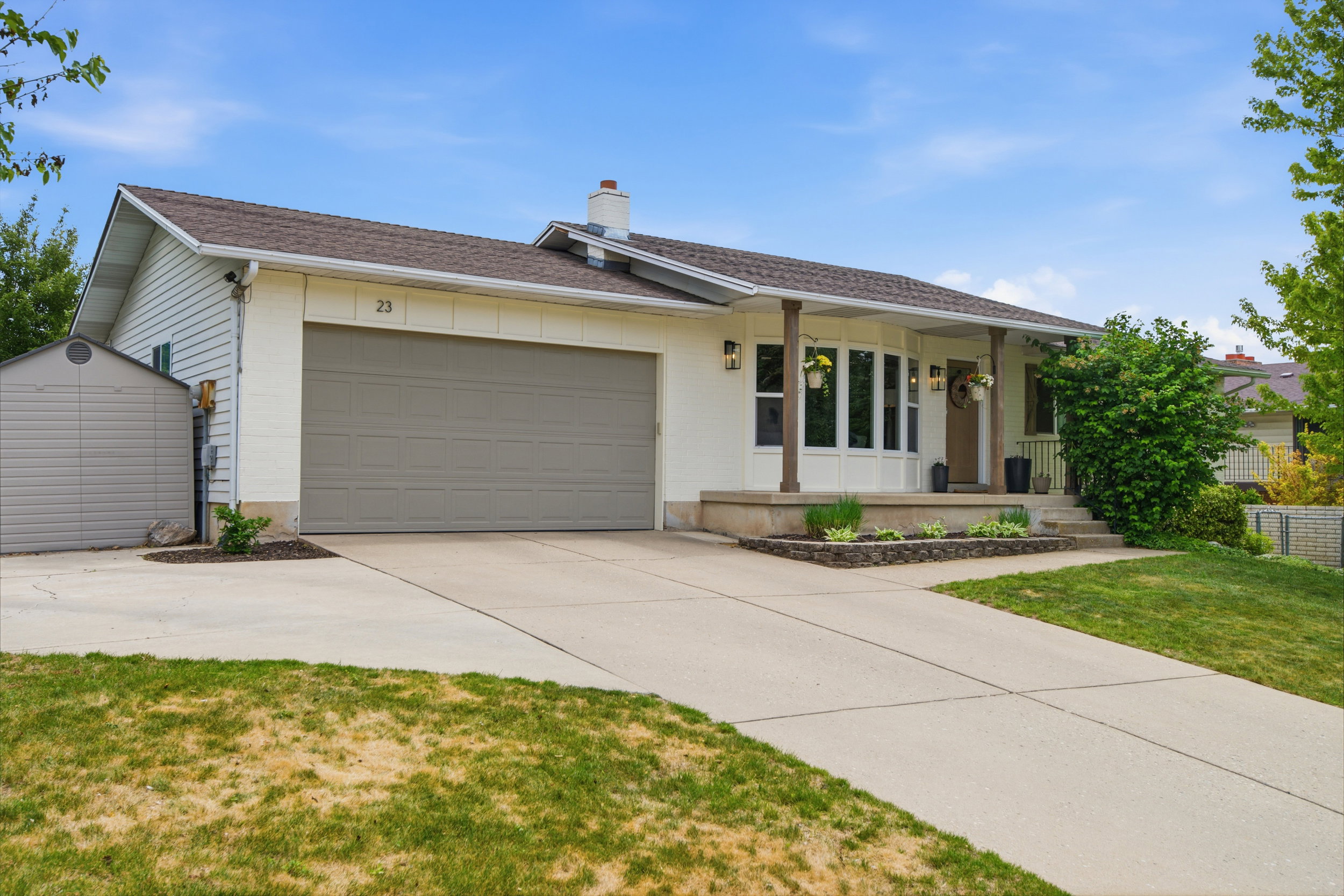 Single-story residence featuring a two-car garage, concrete driveway, and a front porch with decorative pillars