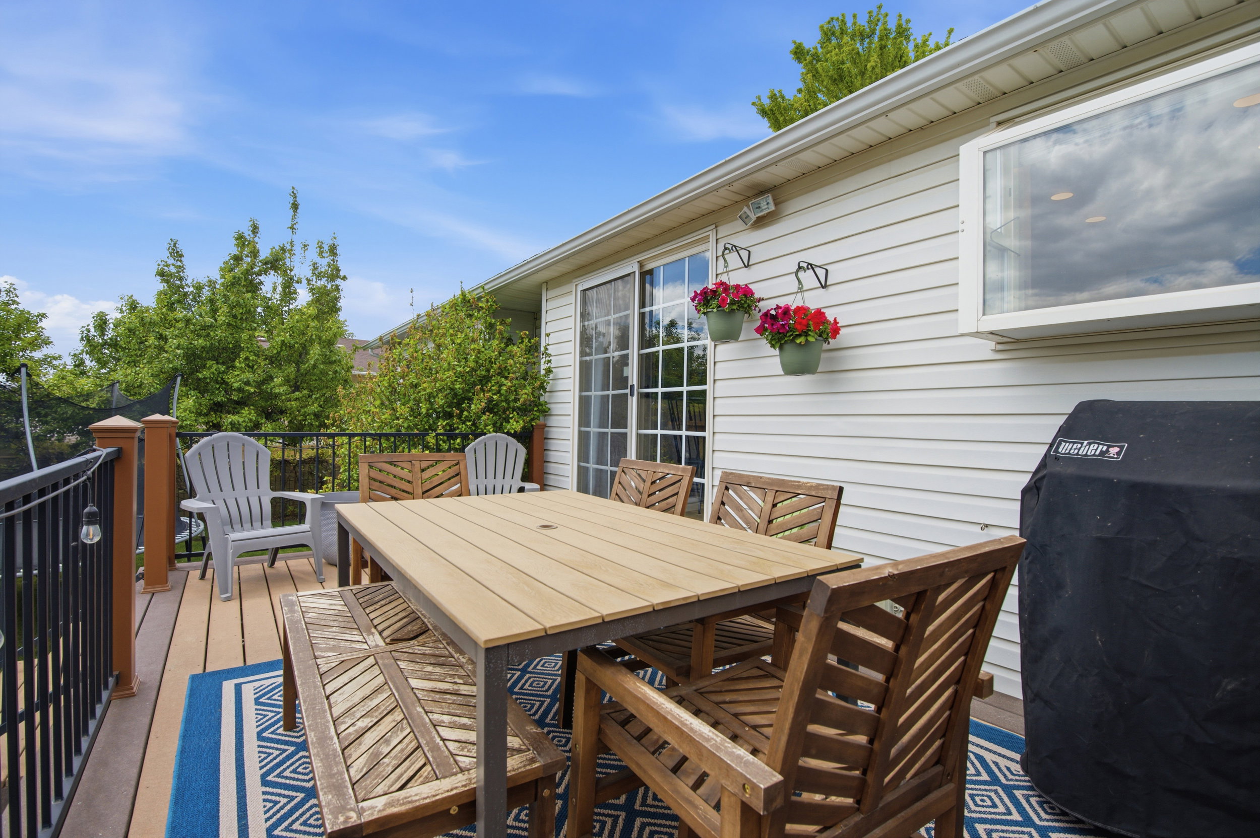 Spacious outdoor deck featuring wood-finish flooring and black metal railing