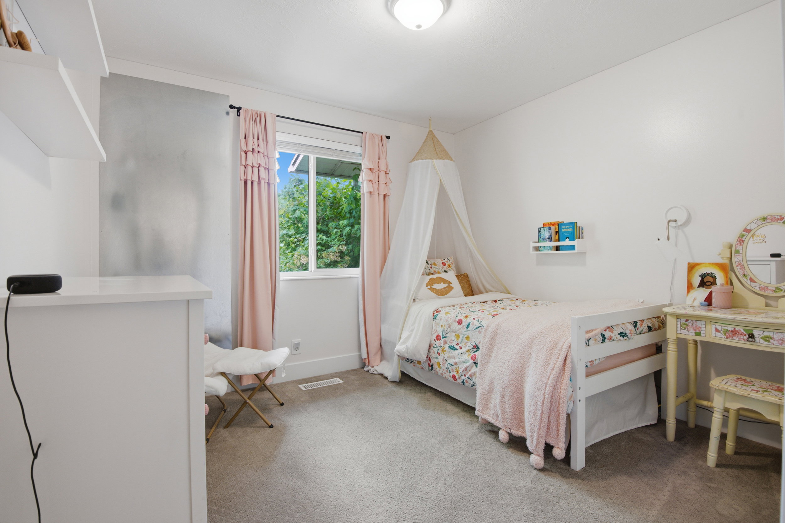 Bright room featuring a window with exterior tree views, wall-to-wall carpeting, and a flush mount ceiling light fixture