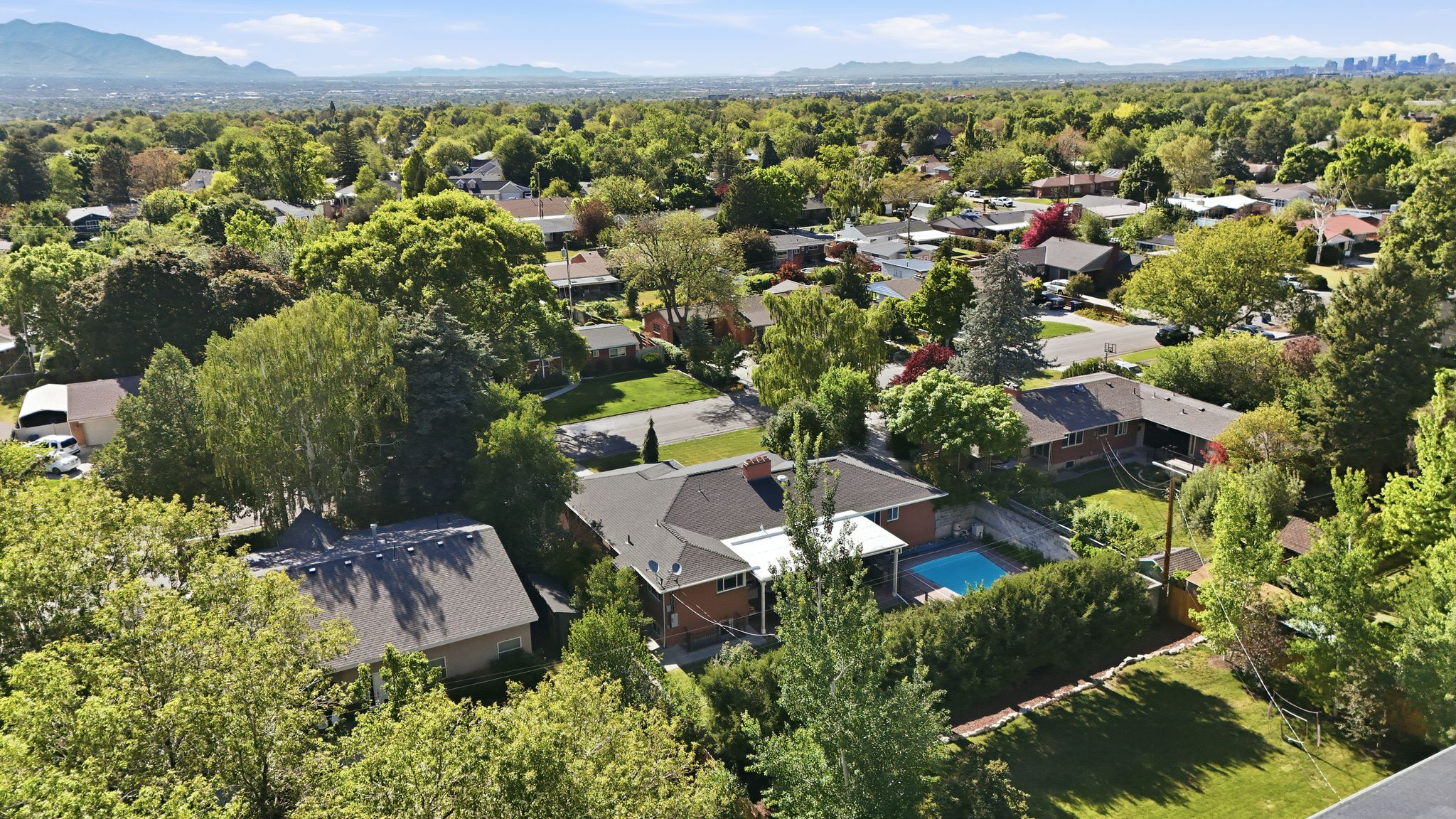 Aerial perspective showcasing a residential neighborhood with a variety of mature trees and established properties