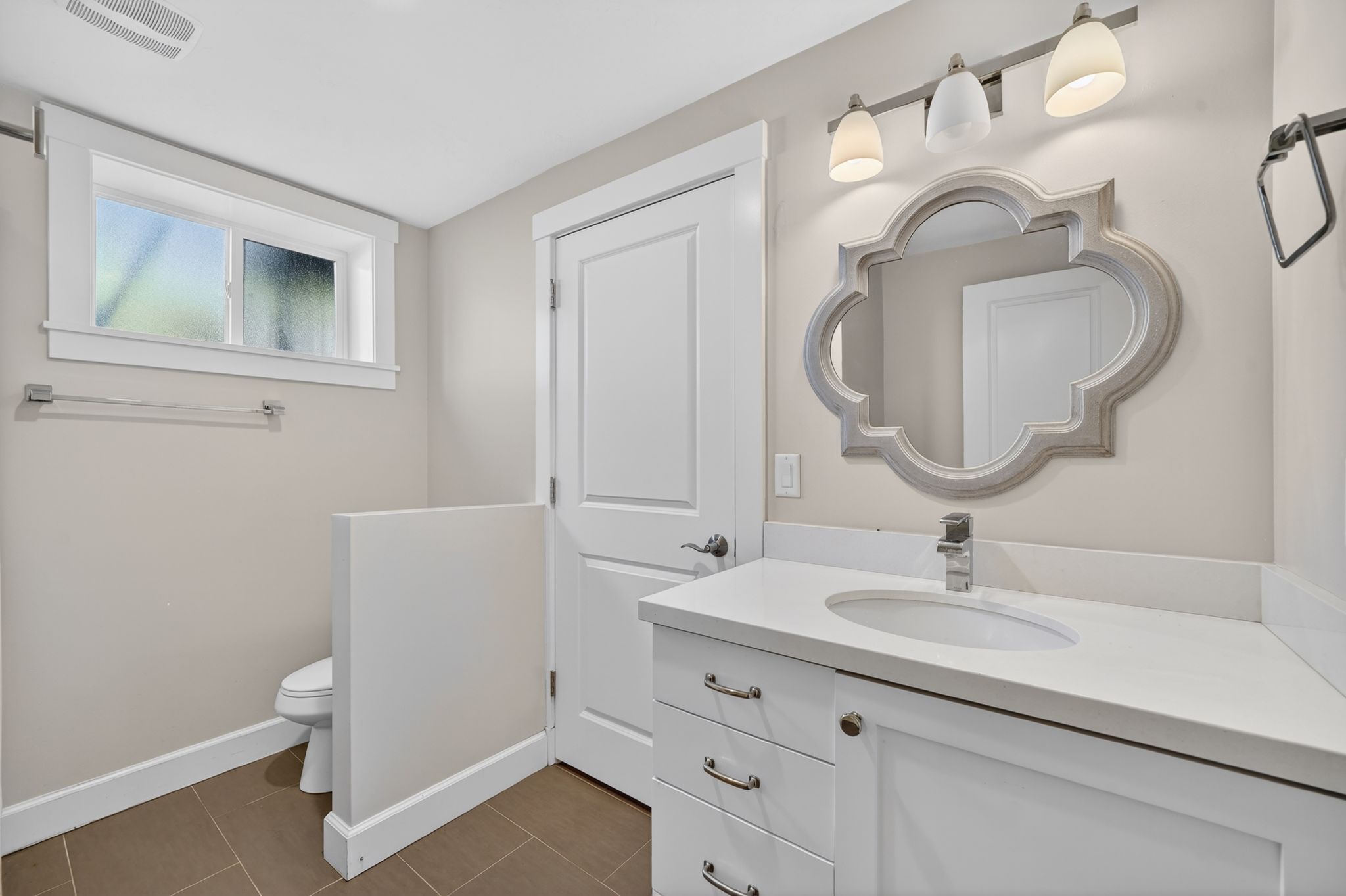 Vanity featuring white cabinetry, a white countertop, and an undermount sink