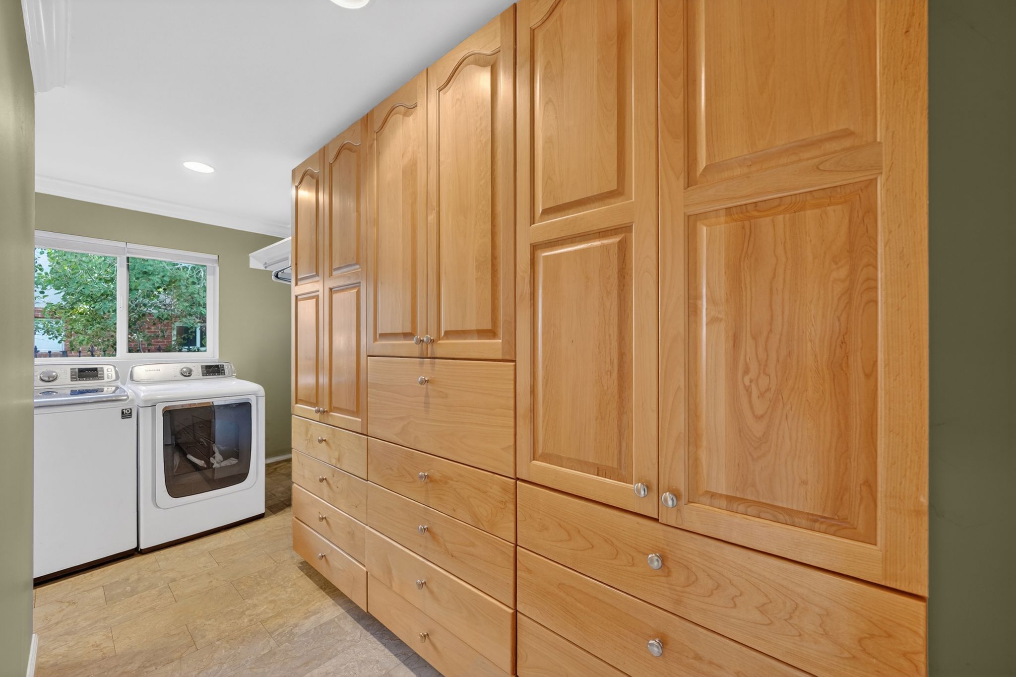 Built-in wood cabinetry with panel doors and crystal knobs, recessed ceiling lighting, and a large window