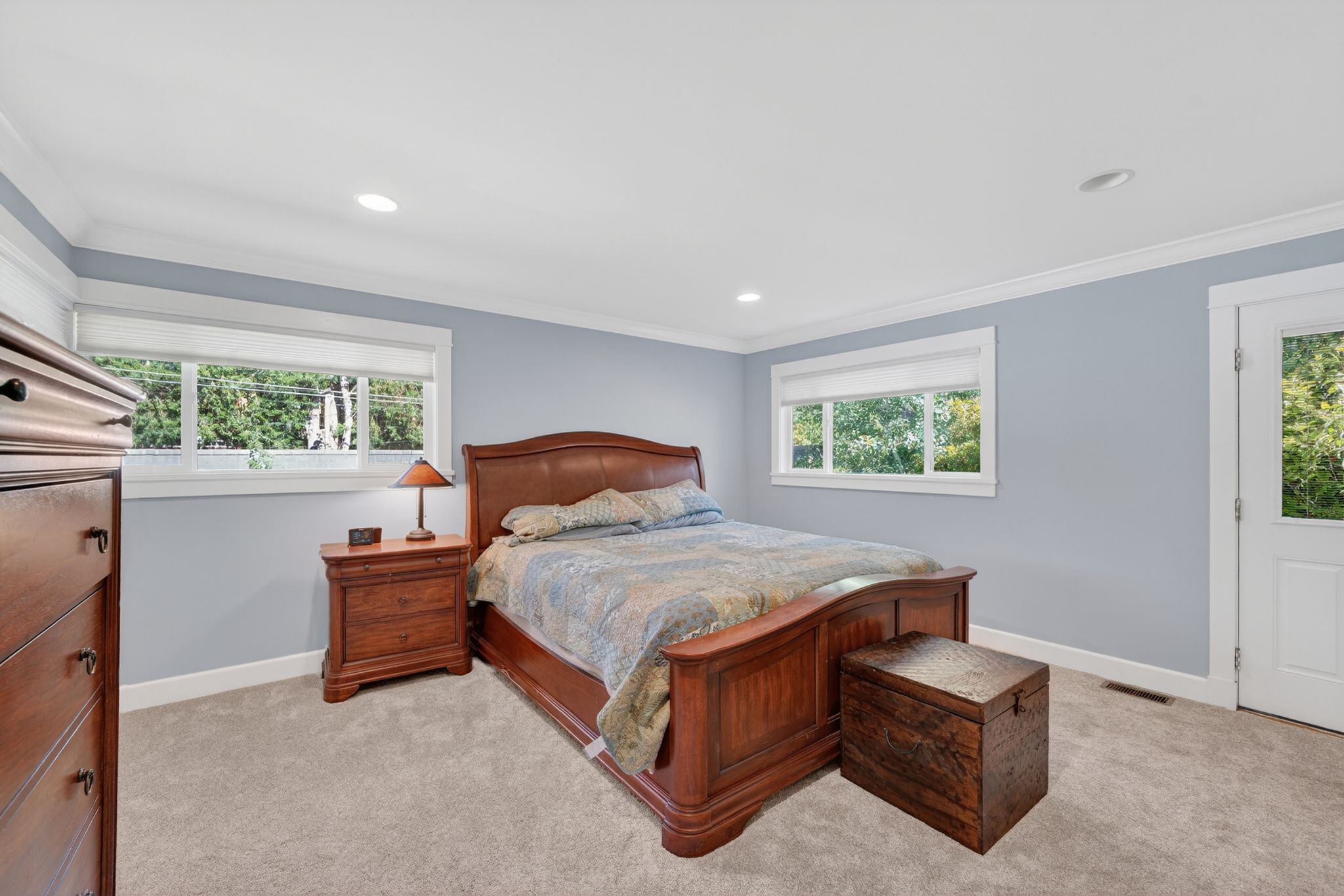 Bedroom with light blue walls, white trim, and recessed lighting
