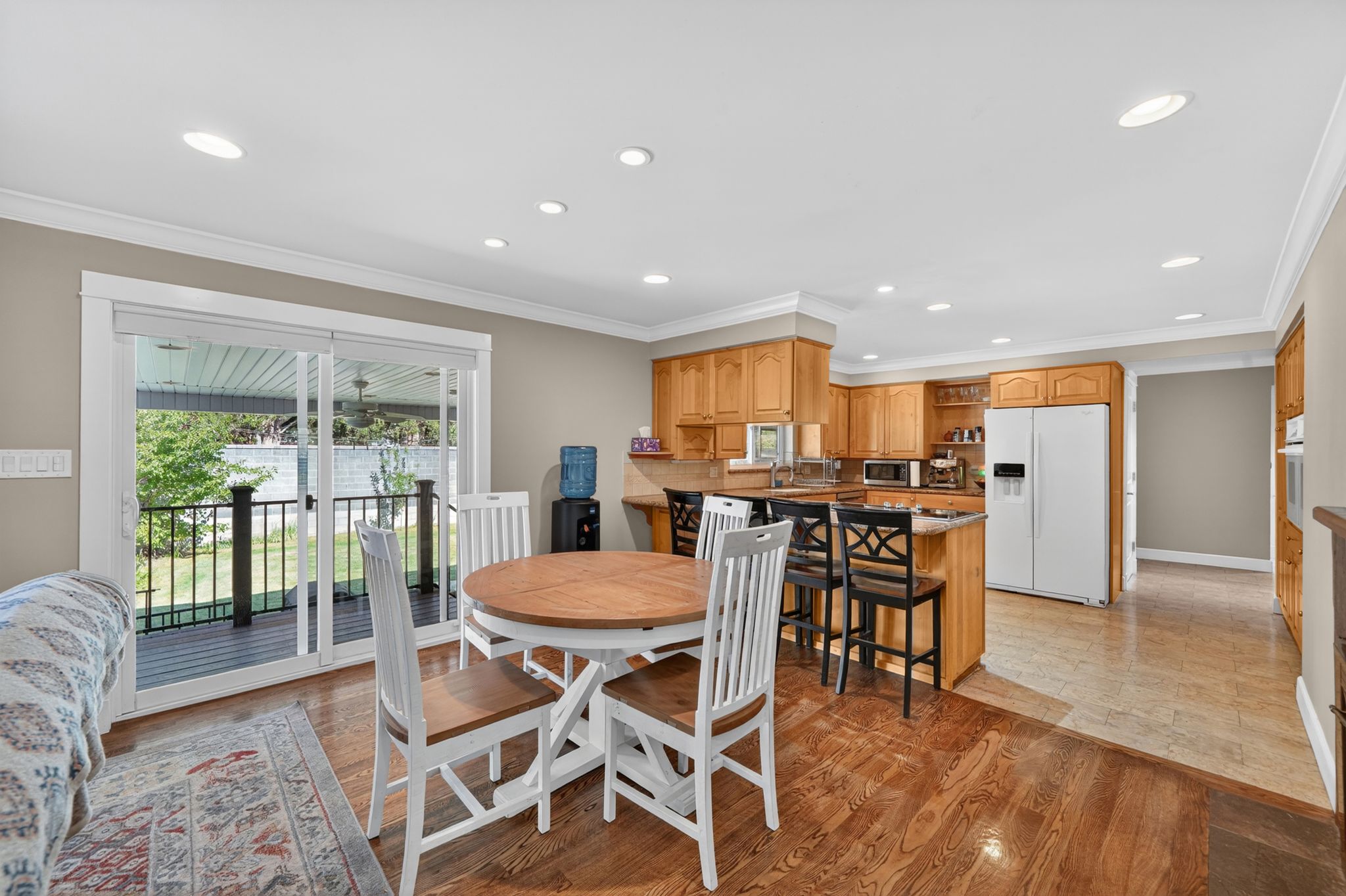 Open-concept living space featuring wood-finish flooring, recessed lighting, and crown molding