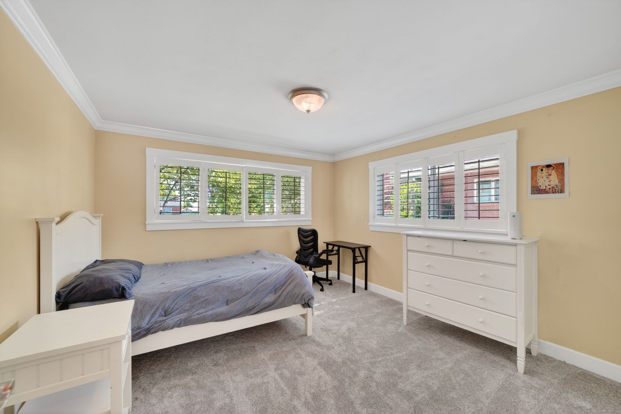 Room featuring neutral-toned walls, white crown molding, and light gray carpet