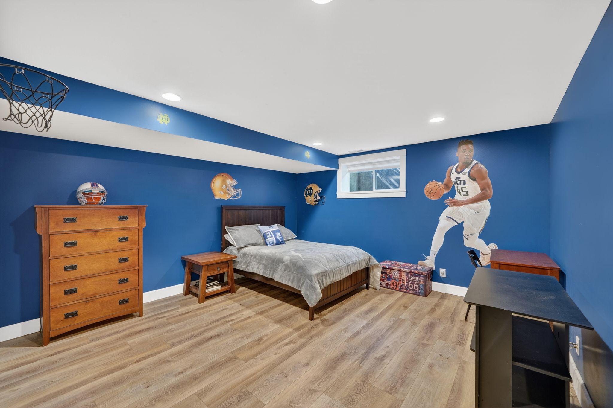Spacious room featuring wood-finish flooring and recessed lighting