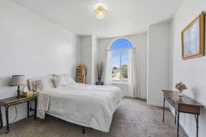 Arch-top window with bright natural light, complementing the neutral wall tones and textured carpeting