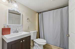 Bathroom featuring a vanity with wood-finish cabinetry, a white basin sink, and a decorative mirror