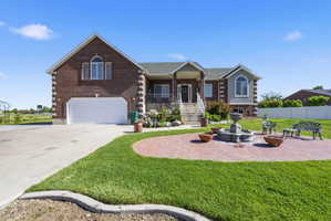 Brick and siding exterior with arched windows, featuring an integrated two-car garage
