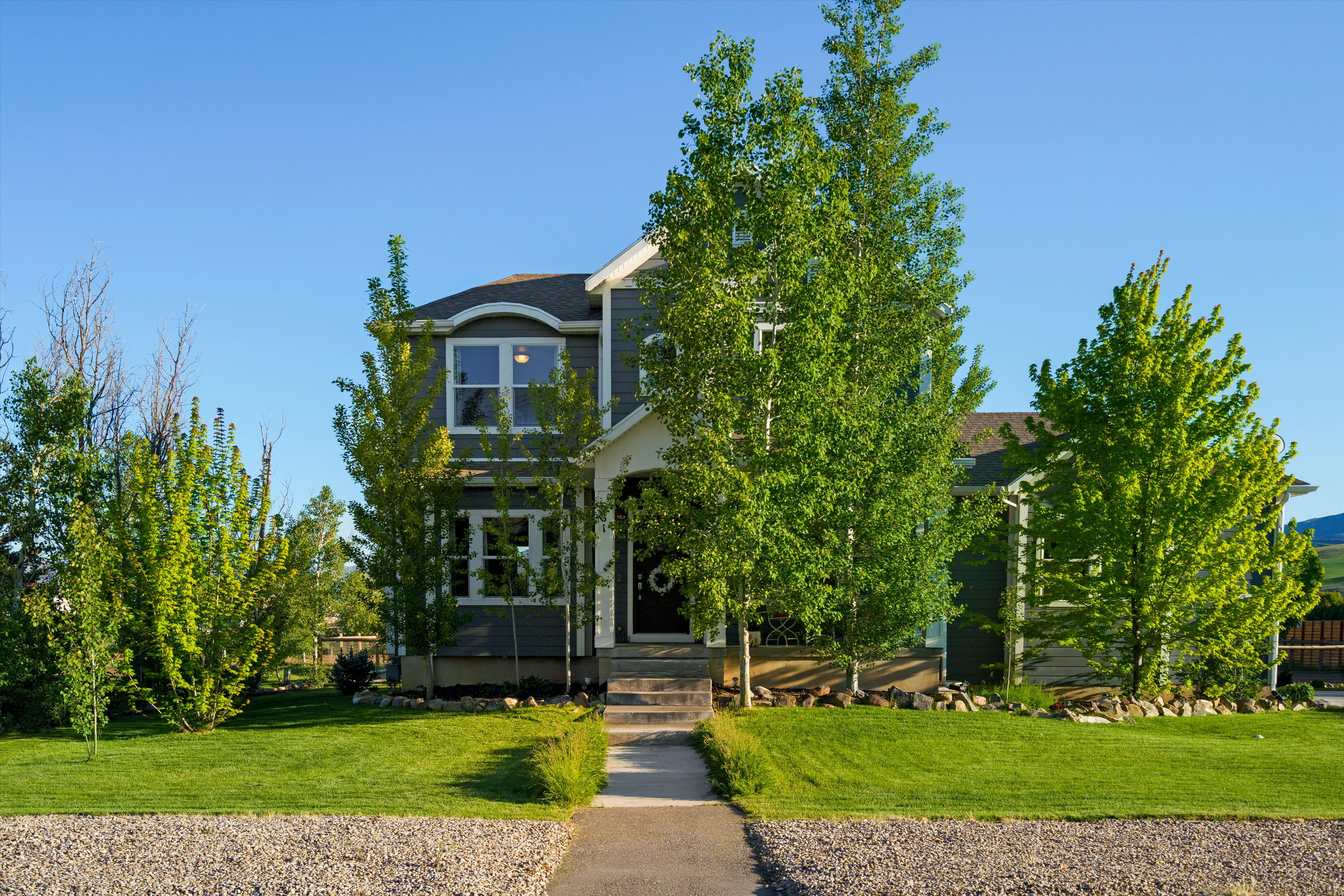 Two-story home with dark gray siding, white trim, and a prominent front entrance