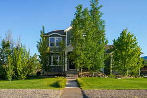 Two-story home with dark gray siding, white trim, and a prominent front entrance