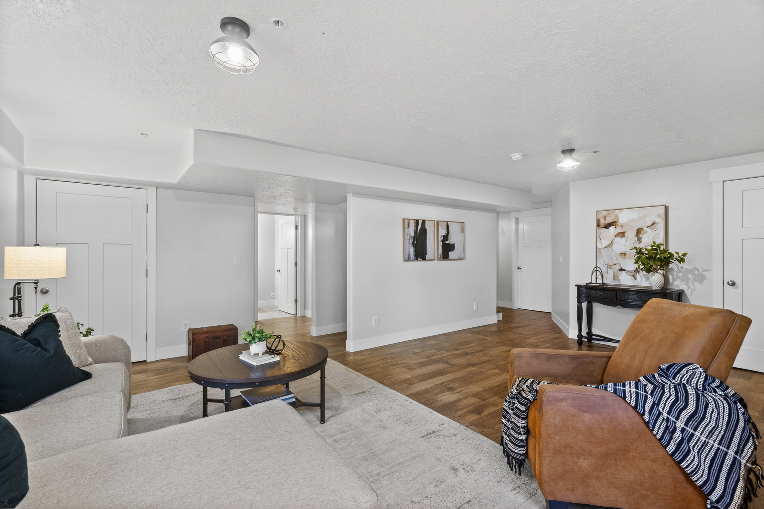 Spacious living area featuring wood-finish flooring, light gray walls, white trim, and recessed lighting