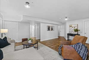 Spacious living area featuring wood-finish flooring, light gray walls, white trim, and recessed lighting