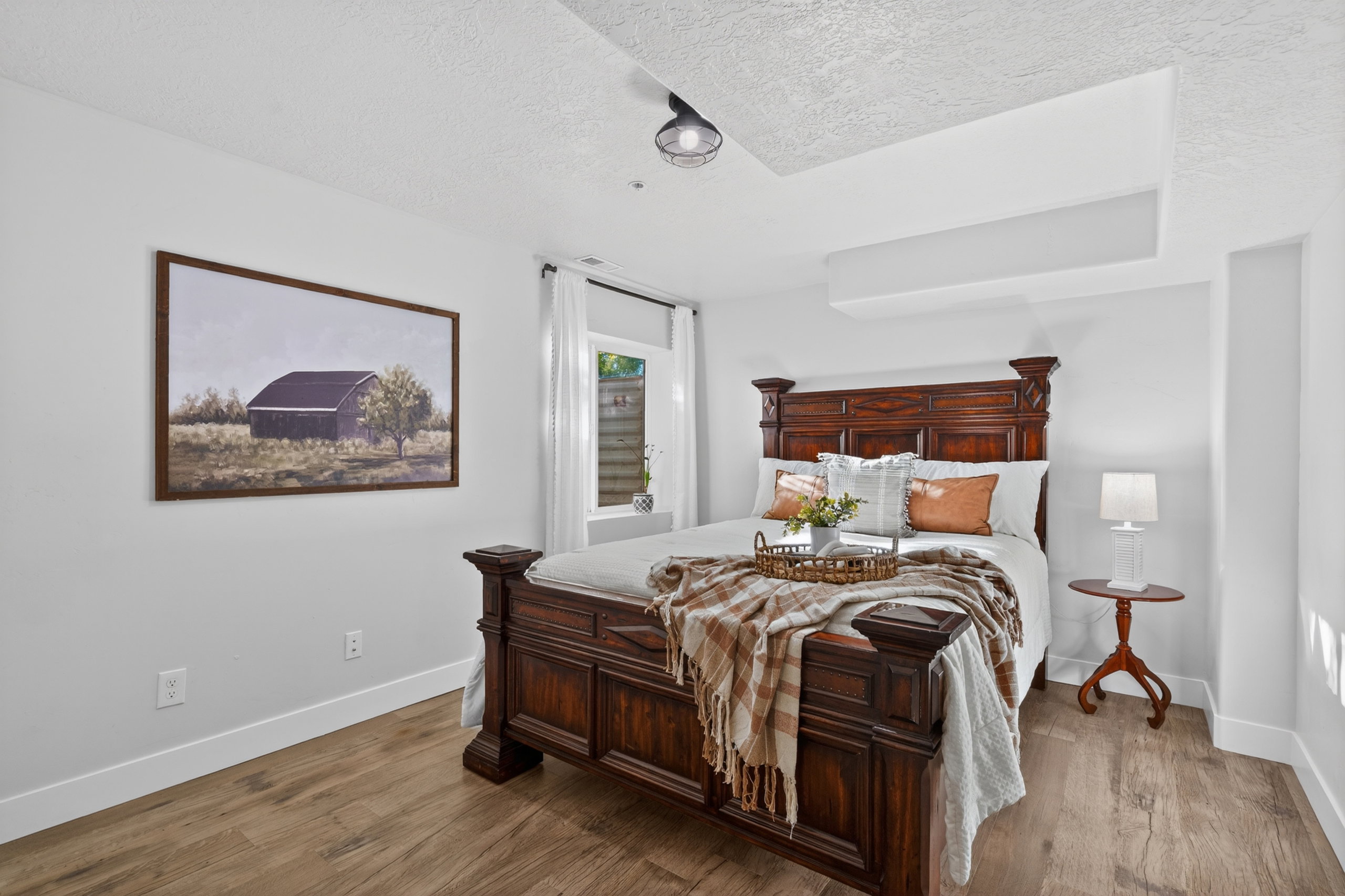 Bedroom featuring wood-finish flooring, white baseboards, and light-colored walls
