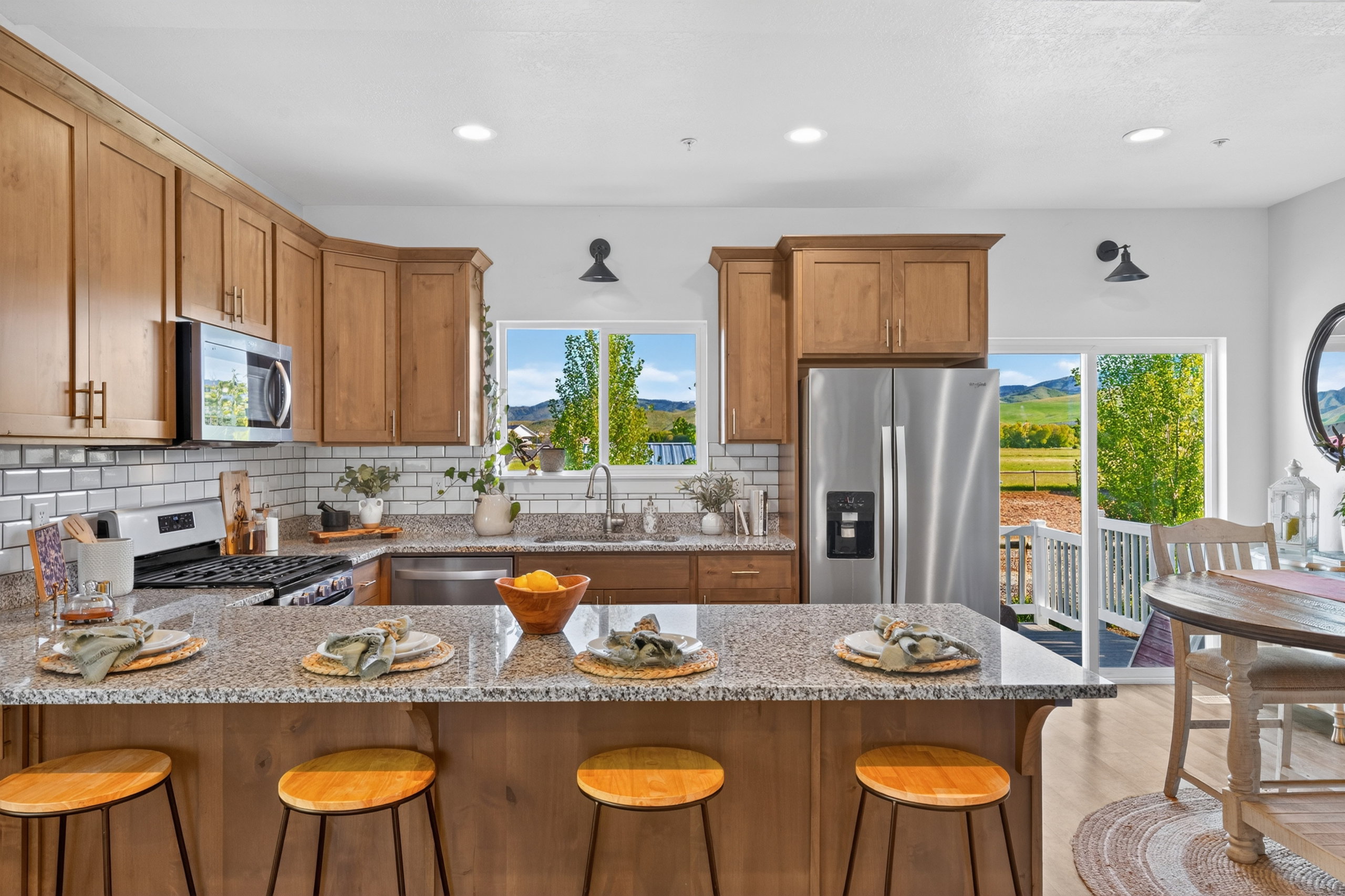 Kitchen featuring granite countertops, wood cabinetry, stainless steel appliances, and a subway tile backsplash