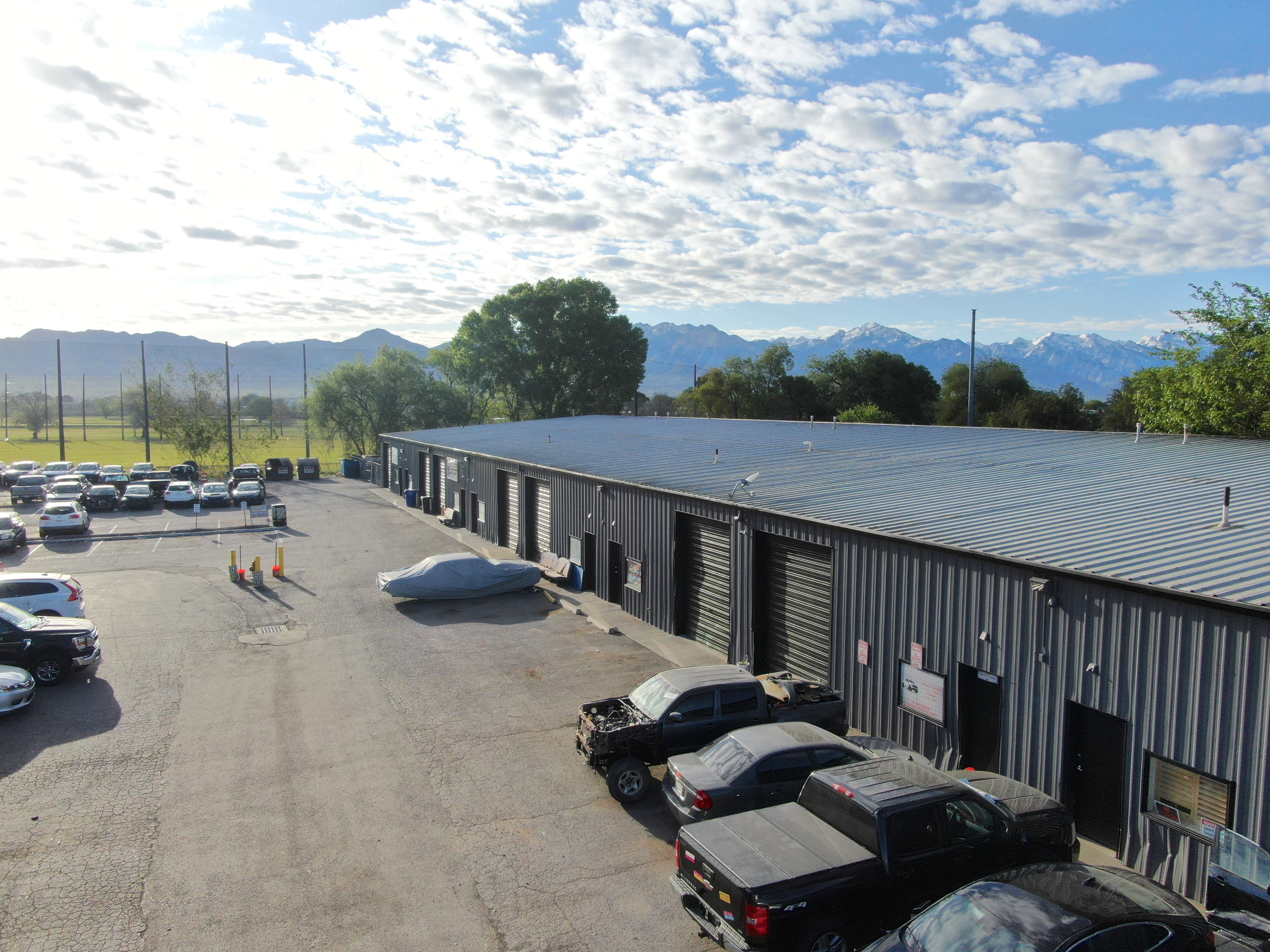 Industrial building featuring a corrugated metal exterior, multiple bay doors, and a metal roof