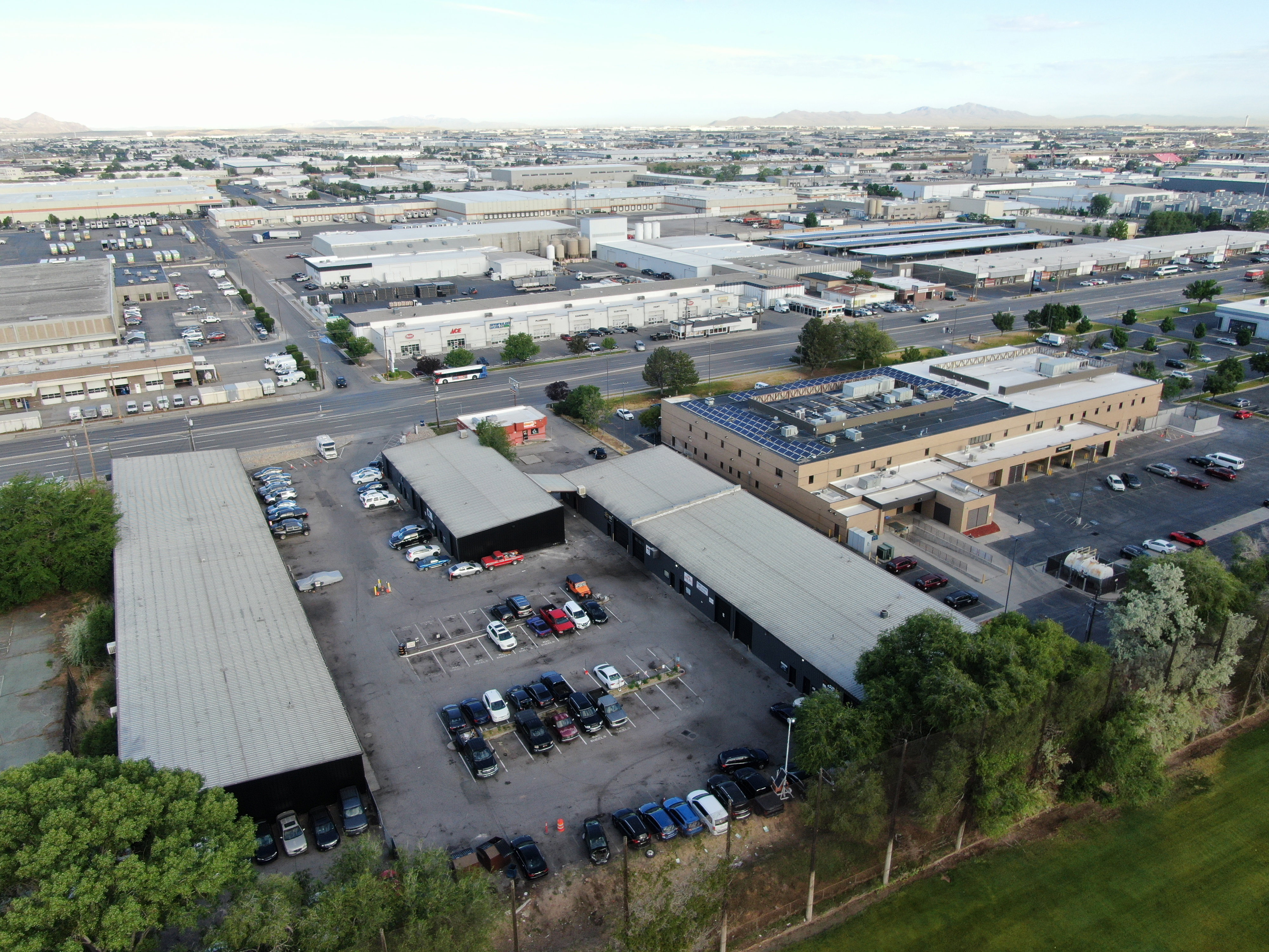 Expansive commercial property featuring multiple buildings, surface parking, and a paved street frontage