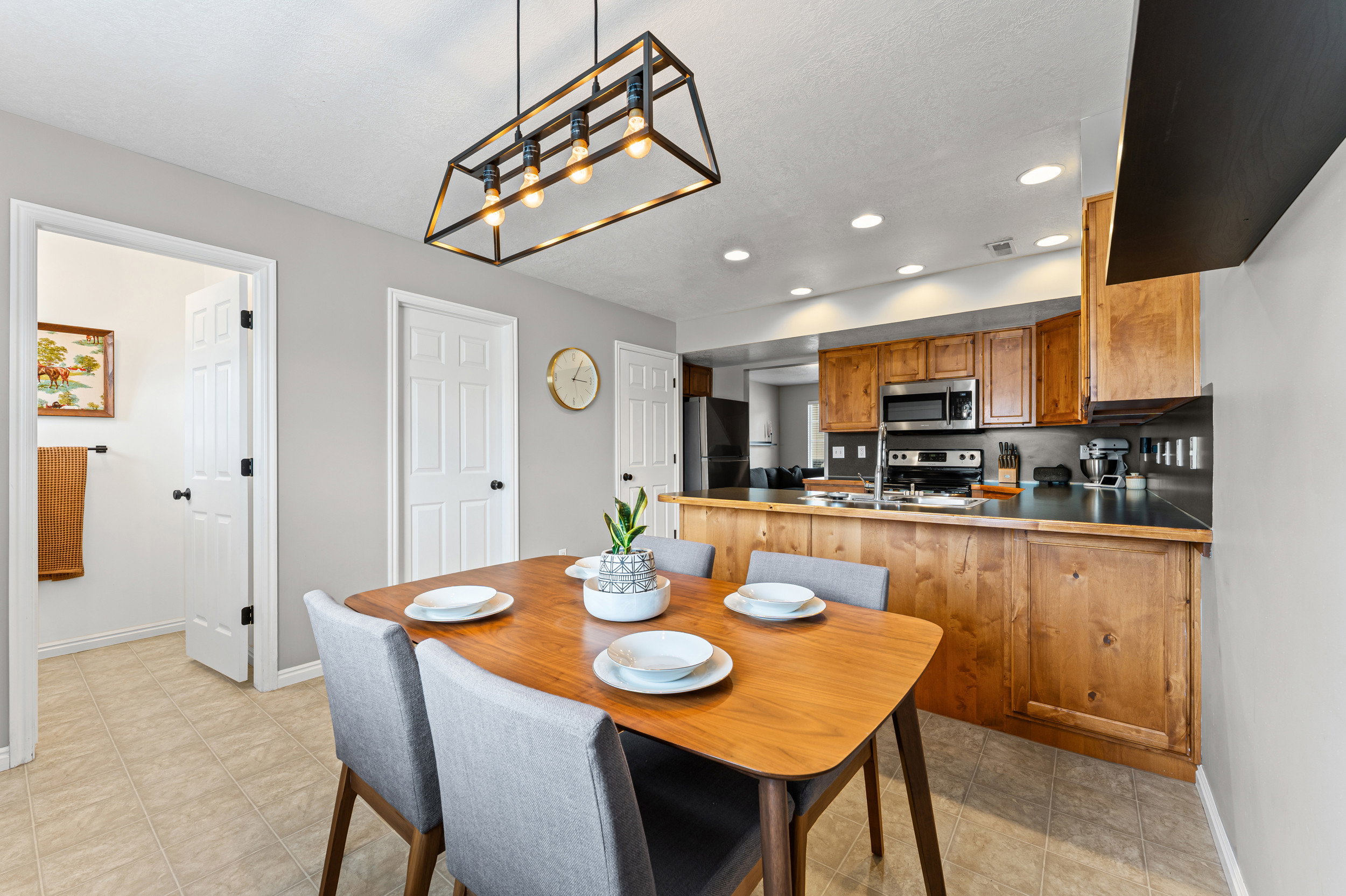 Dining area featuring a contemporary linear chandelier and wood-finish flooring
