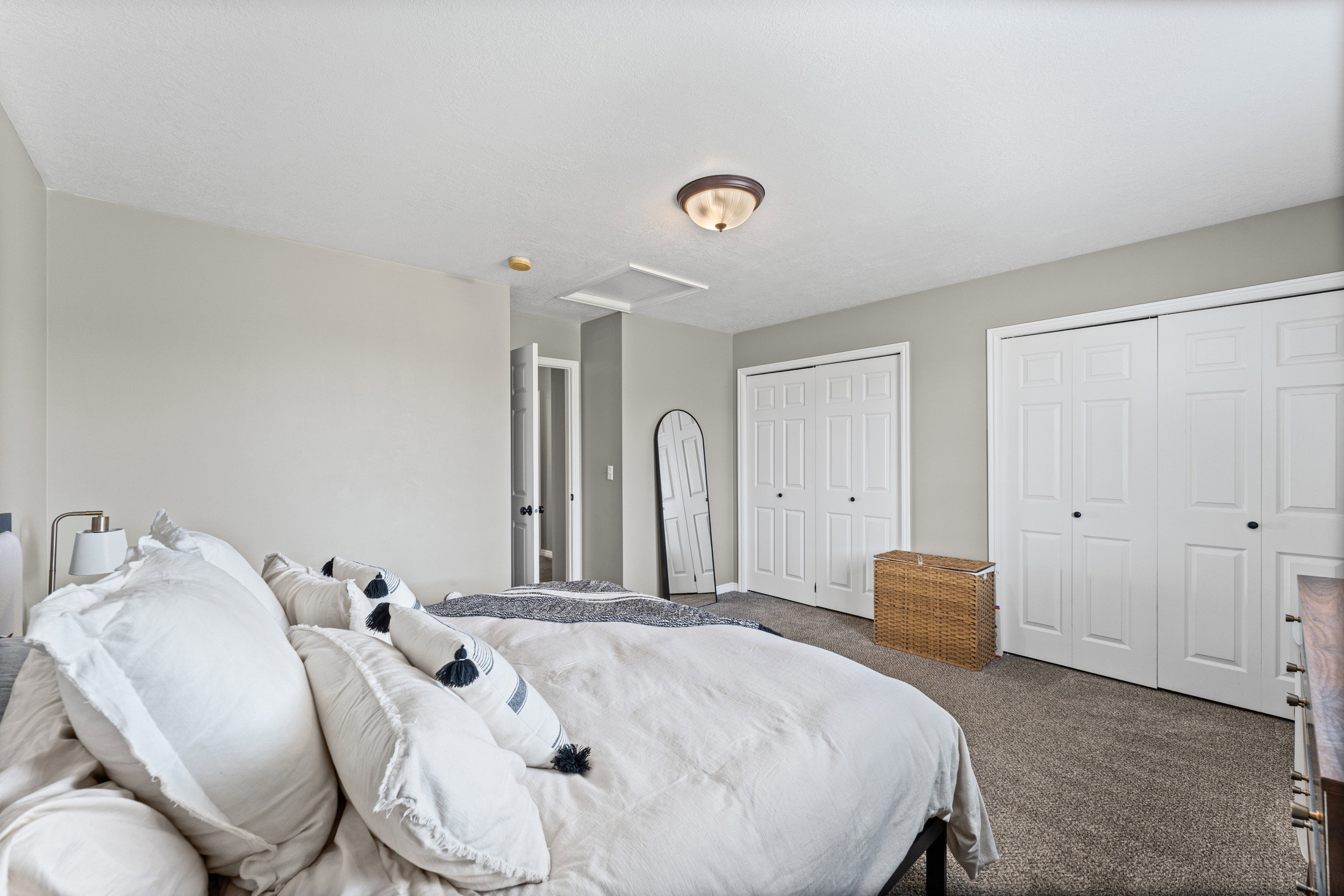 Bedroom featuring dual bi-fold closet doors, additional sliding closet doors, and neutral wall paint