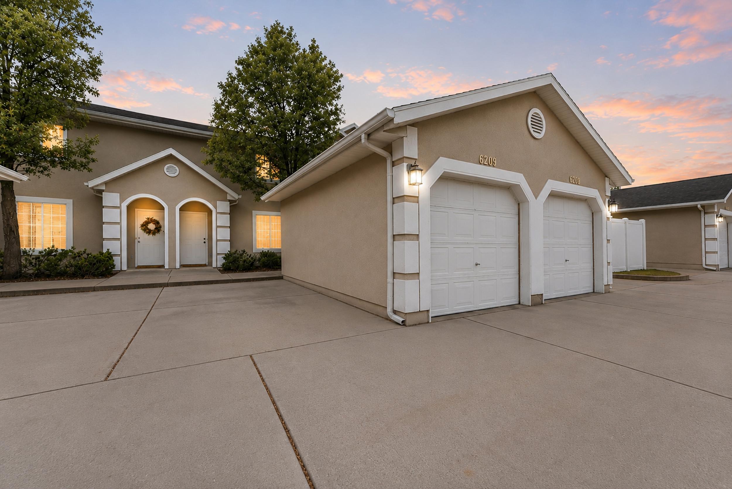 Stucco exterior with two white arched entry doors and a separate two-car garage