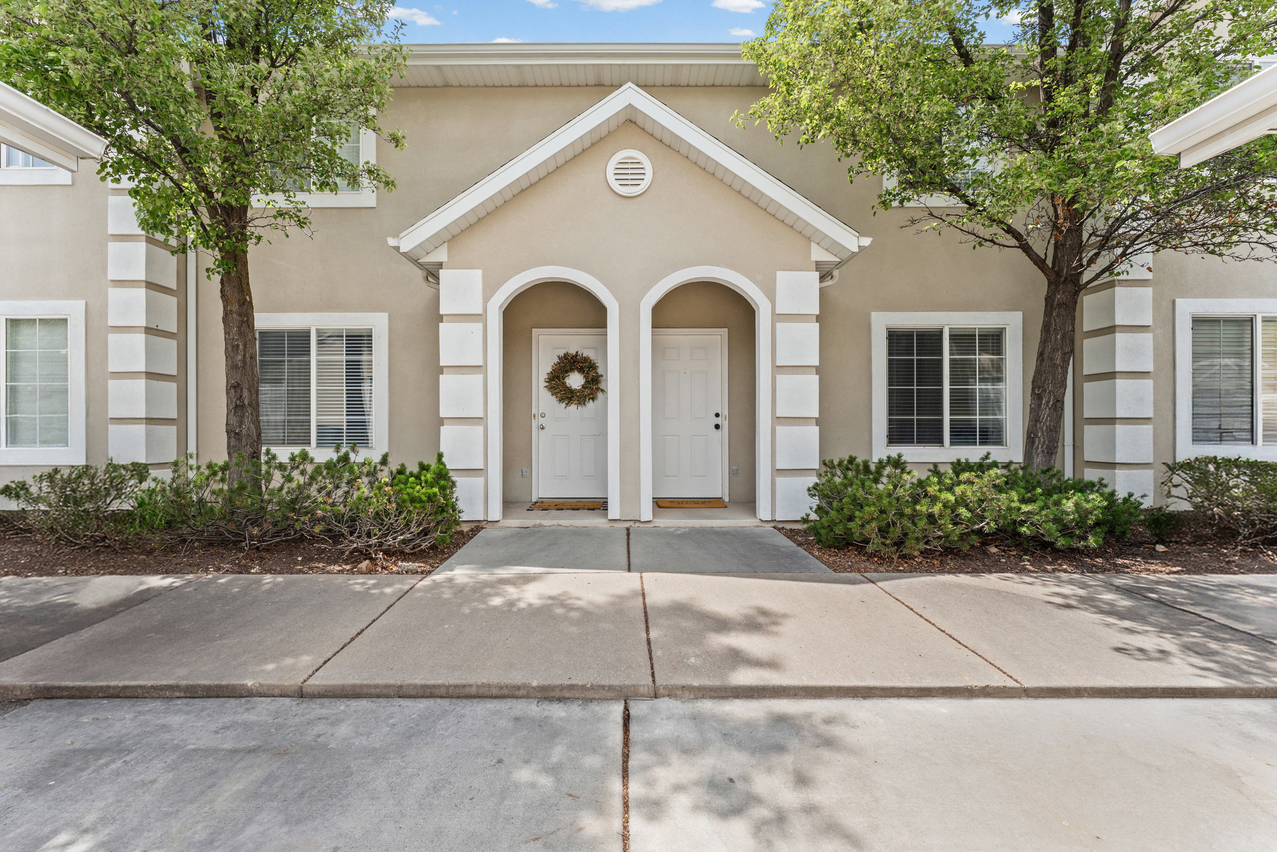 Stucco facade with white trim accents and gabled entryway