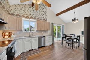 Kitchen and dining area featuring wood-finish flooring, vaulted ceilings with an exposed wood beam, and a ceiling fan