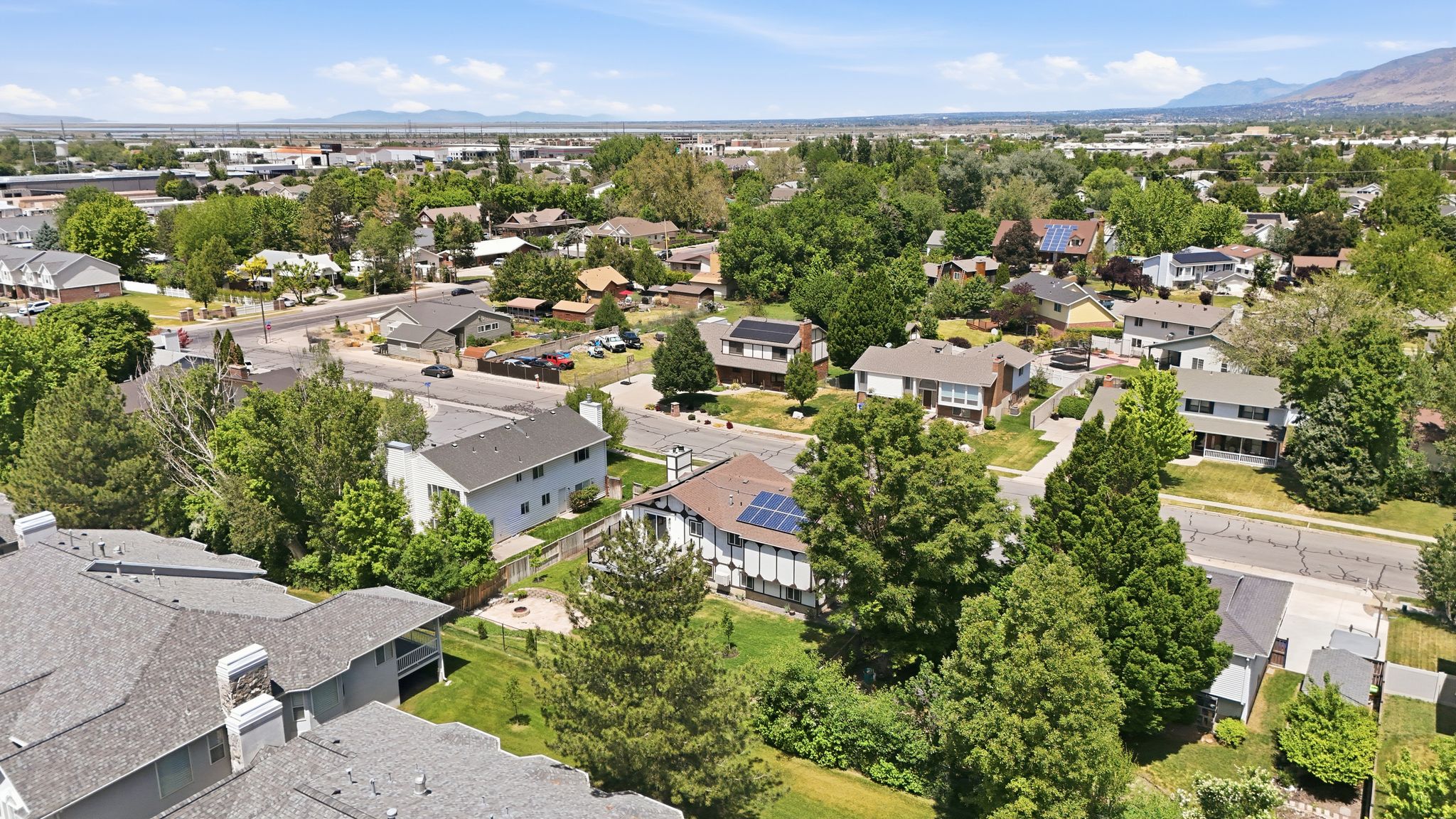 Residential neighborhood featuring mature trees and a clear mountain backdrop
