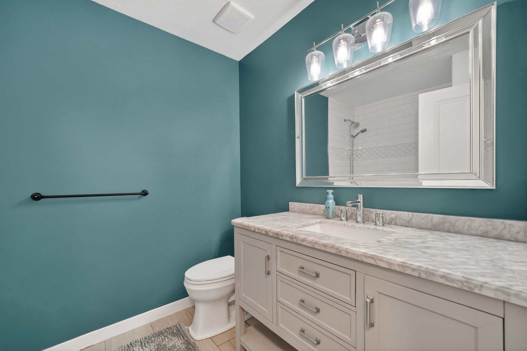 Bathroom featuring a light grey vanity with a white countertop and an undermount sink