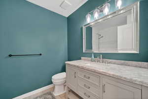 Bathroom featuring a light grey vanity with a white countertop and an undermount sink
