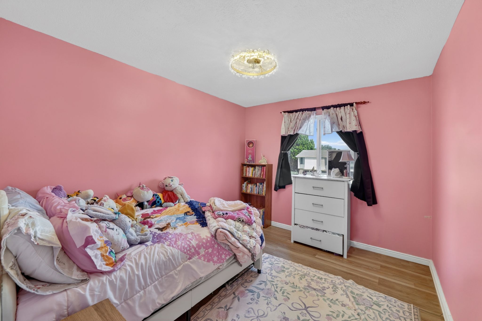 Room featuring light wood-finish flooring, a window providing natural light, and a built-in light fixture