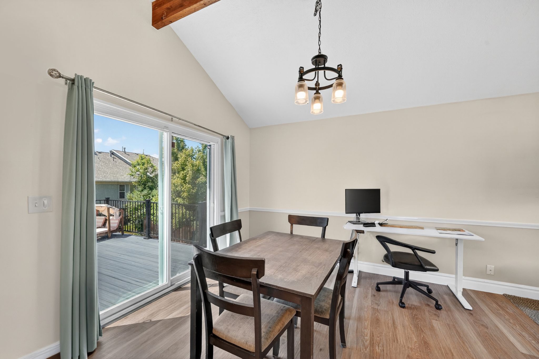 Vaulted ceiling with exposed wood beam and a contemporary chandelier