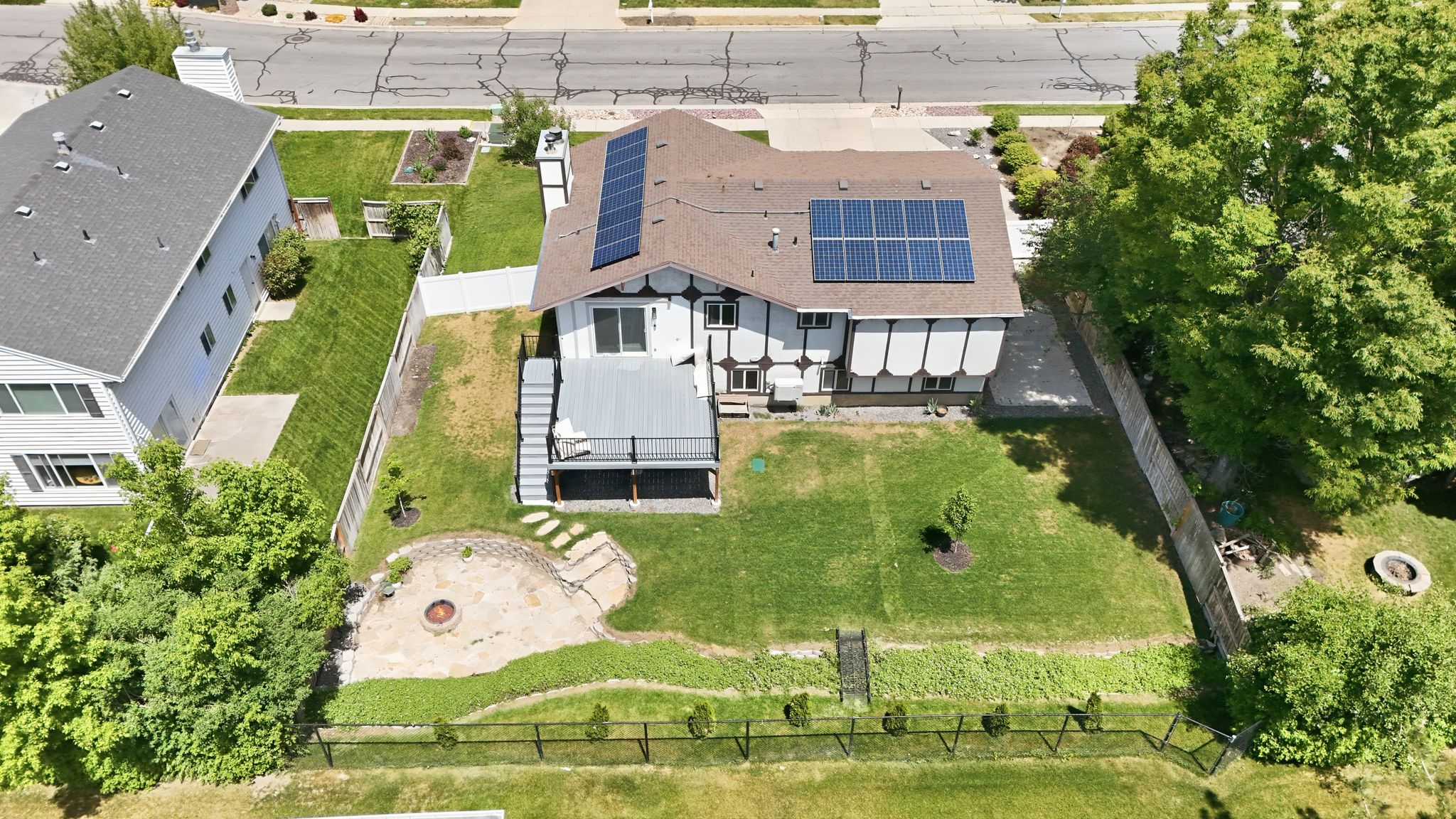 Two-story residence featuring a brown shingle roof with solar panels