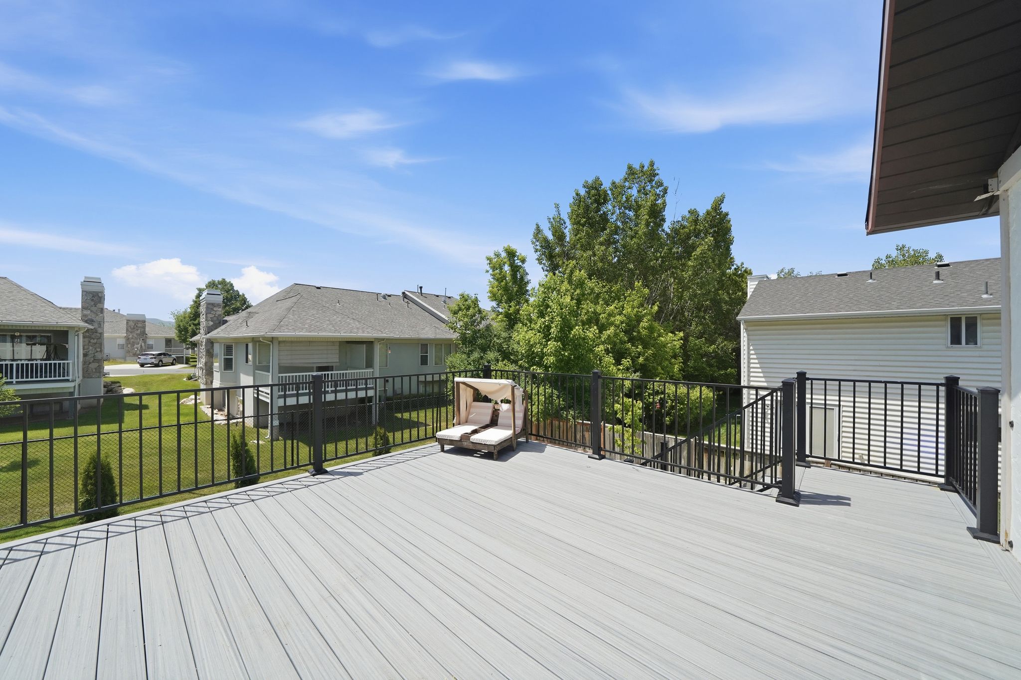 Spacious outdoor deck featuring composite decking and black metal railings