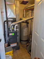 Utility room featuring a furnace system with associated ductwork and a water heater