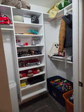 Built-in white shelving system featuring multiple storage compartments and a hanging rod