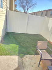 Private outdoor space featuring a concrete patio and a fenced yard with green turf