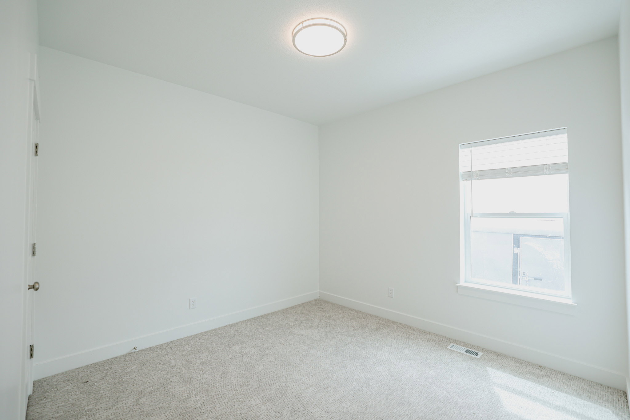 Neutral carpeting with white baseboards and light-colored walls