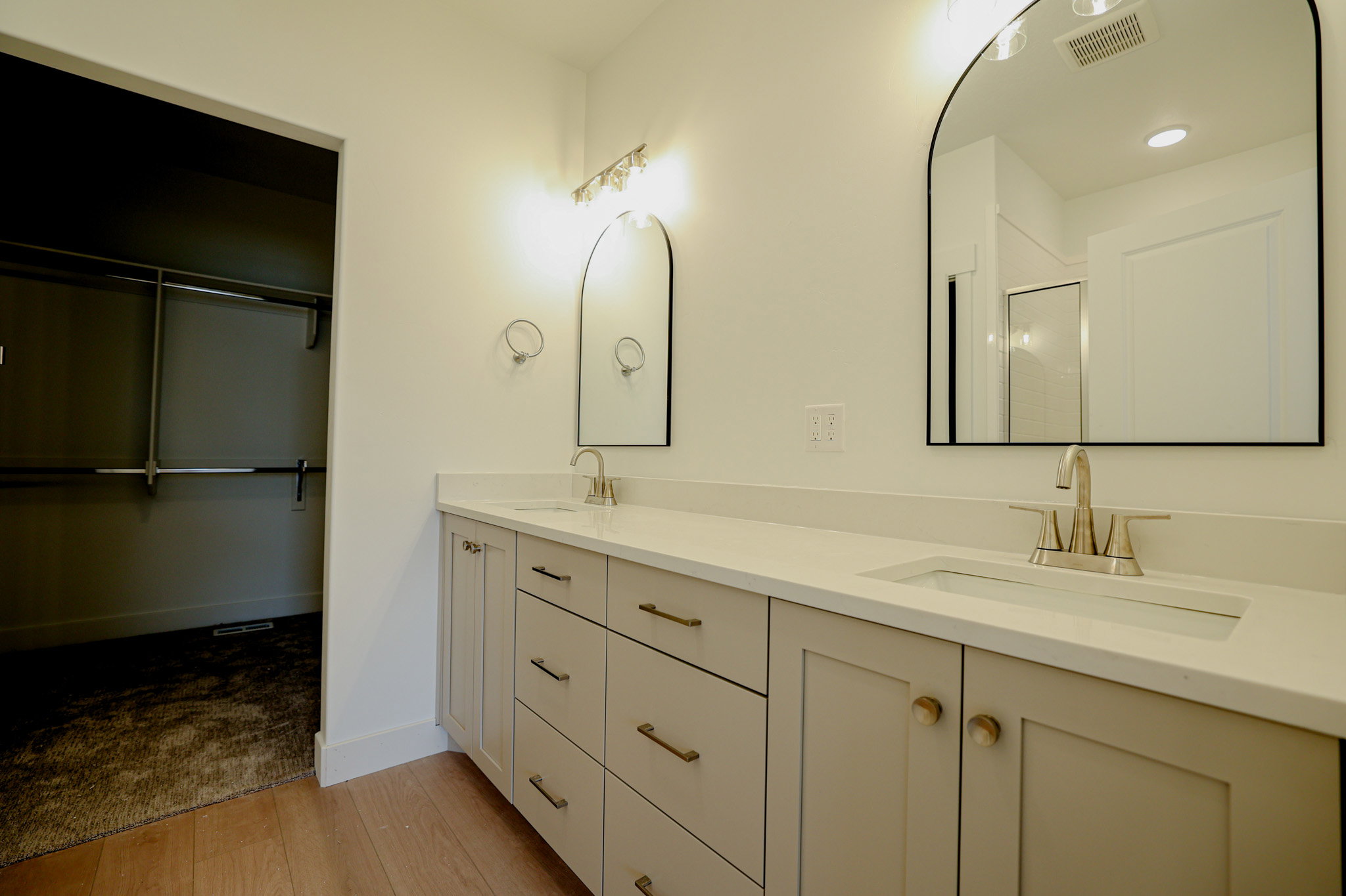 Dual vanity featuring light-toned cabinetry and integrated sinks with brushed nickel fixtures